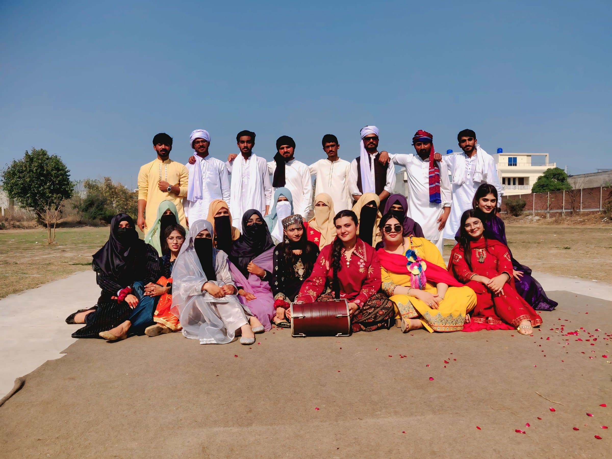 ISSA students in traditional Pakistani dress posing with a dhol on the campus ground on Culture Day