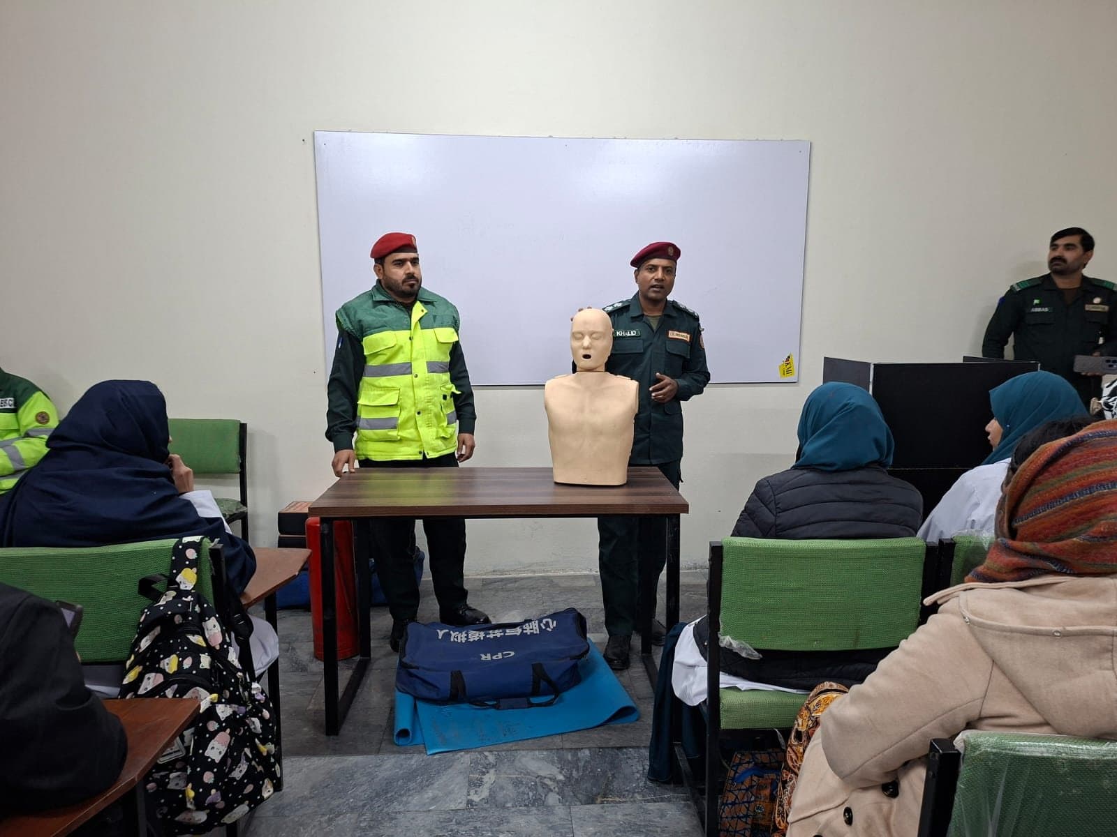 Rescue 1122 trainers demonstrating CPR on a manikin to ISSA students
