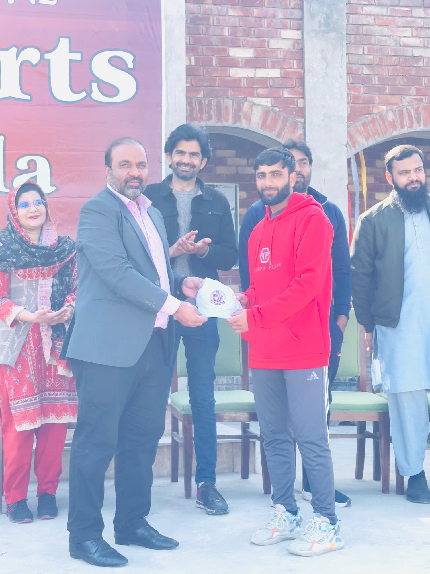 A faculty member presenting an award to a student at the Sports Gala