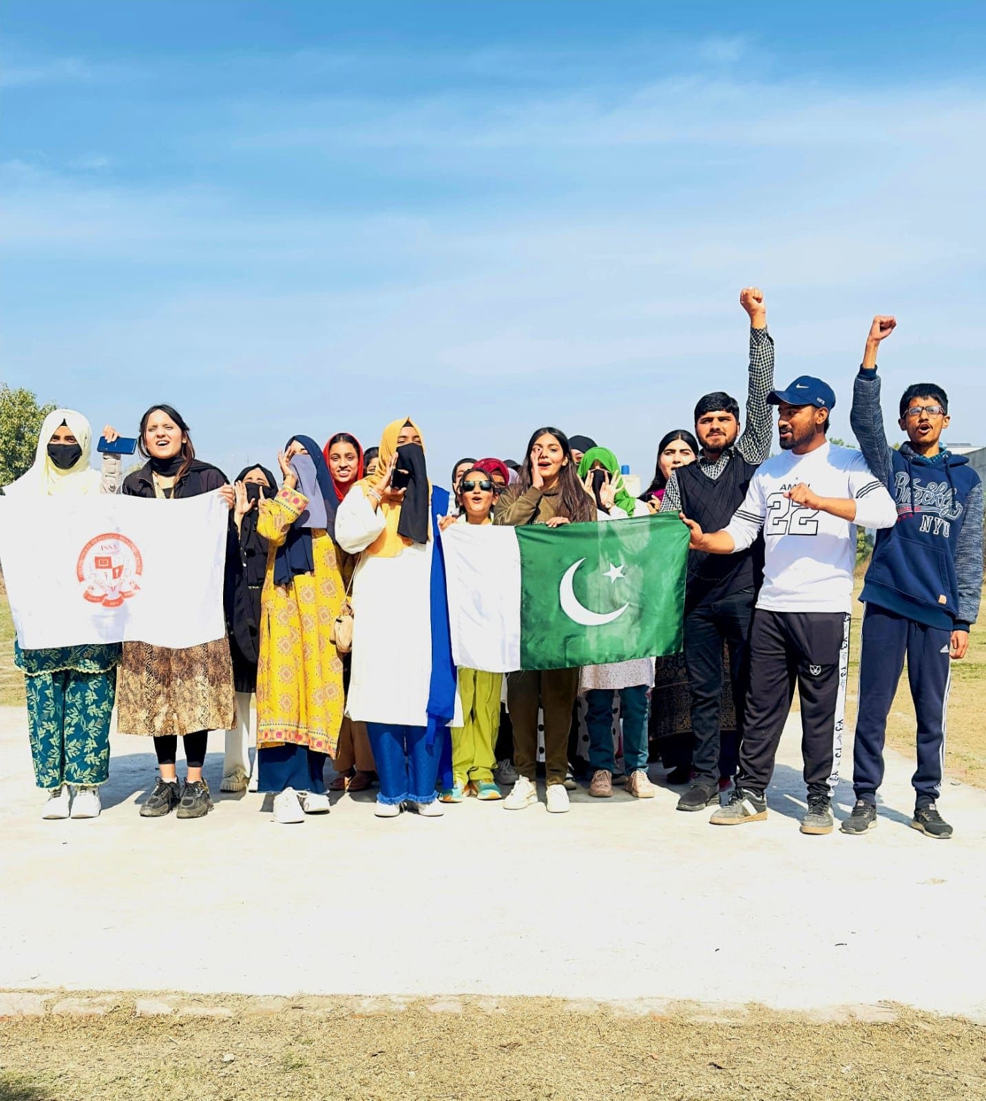 Students cheering with the ISSA and Pakistan flags on the sports ground