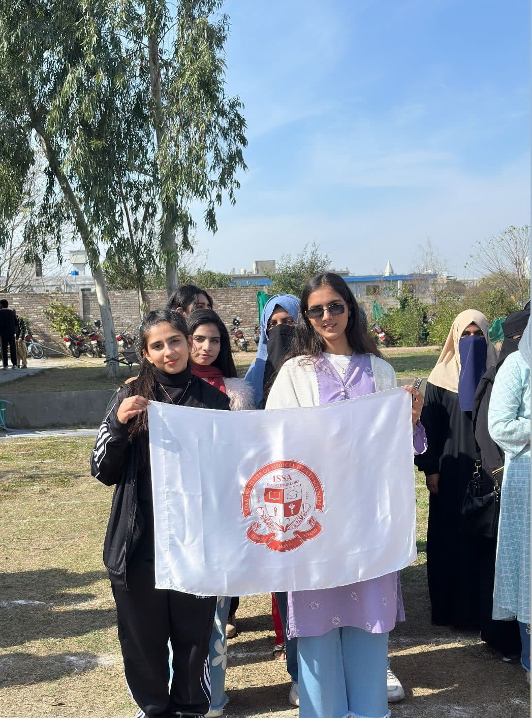 Students holding the ISSA flag on the sports ground