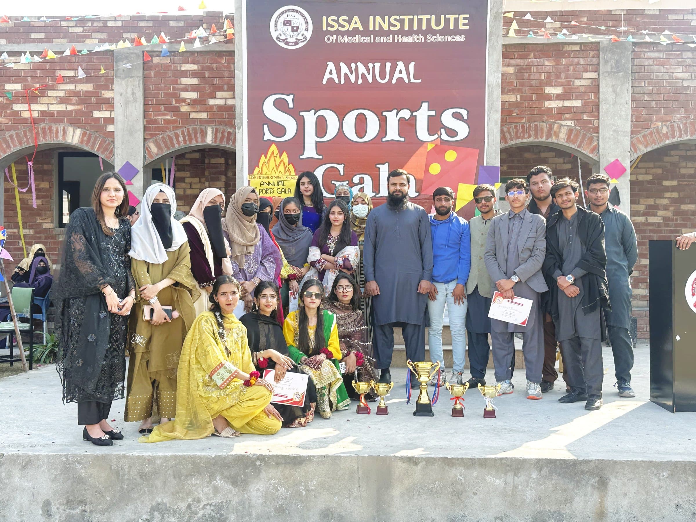 Prize winners with trophies and certificates on the stage in front of the Annual Sports Gala banner