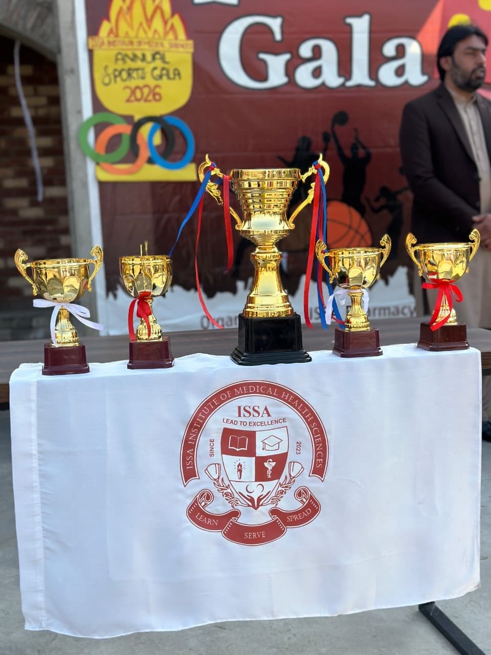 Trophies displayed on a table with the ISSA crest
