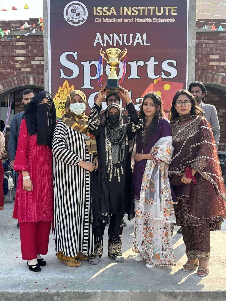Students holding a trophy in front of the Annual Sports Gala banner