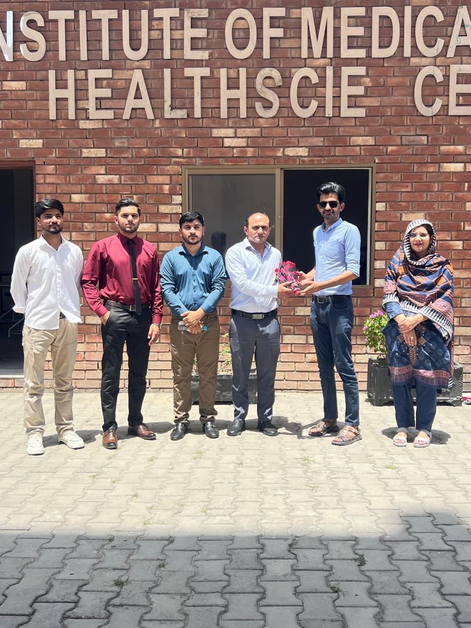 Guests and faculty at the Thalassaemia Screening Camp in front of the Institute of Medical & Health Sciences sign