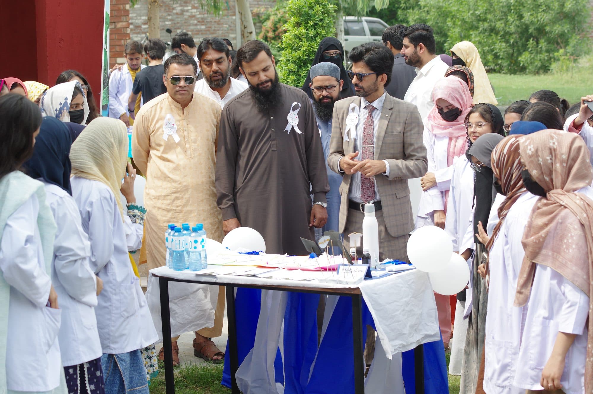 Faculty and students at a display table during World Pharmacists Day