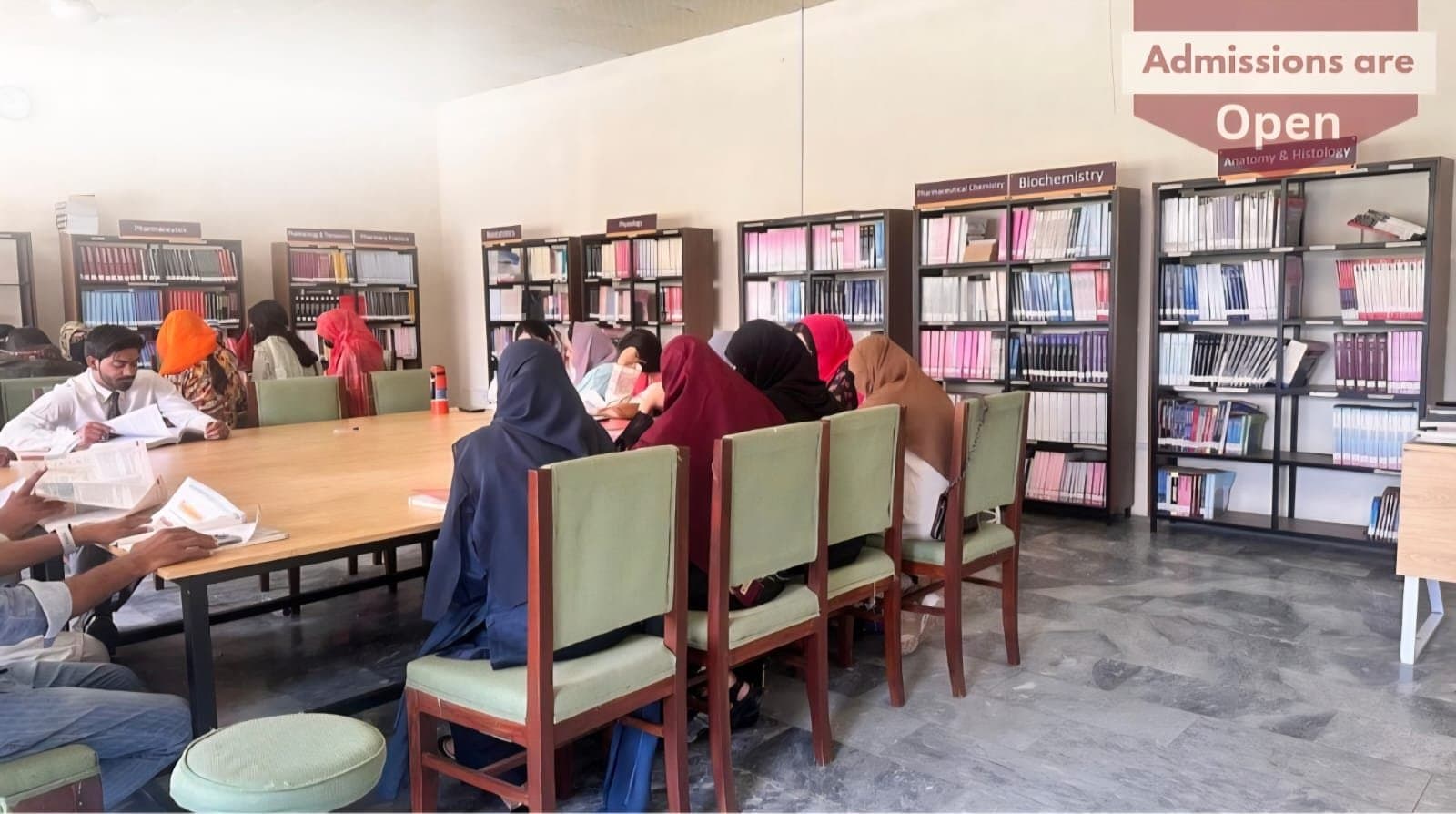 Students reading at the tables of the ISSA library, with bookshelves along the walls