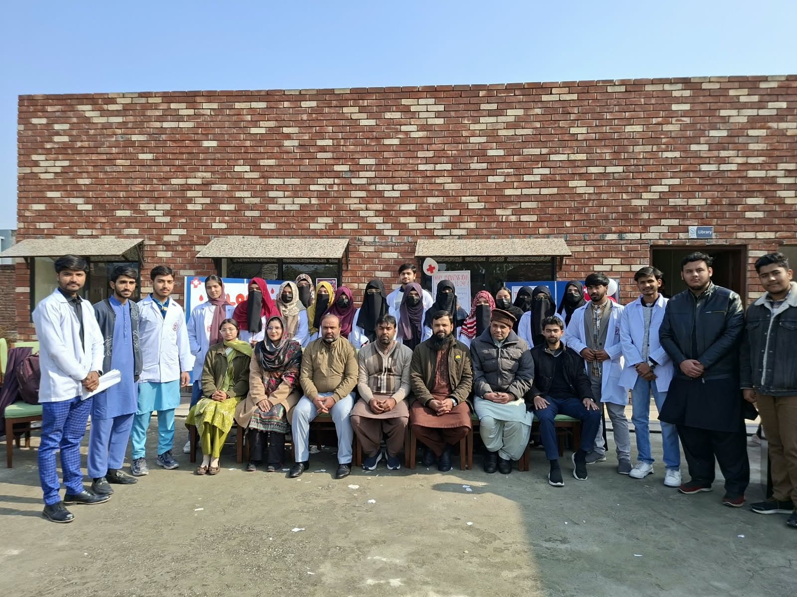 Students in white coats, faculty and volunteers of the ISSA Blood Donation Society at the Blood Screening Camp